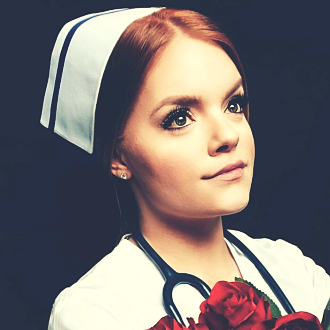 Brianna Seewald in nurses uniform and holding bouquet of red flowers for professional graduation photo