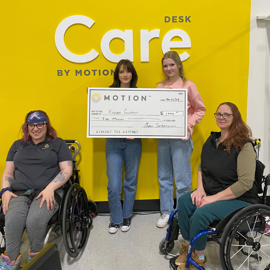 Motion Saskatoon team members holding a novelty cheque representing a donation to Kinsmen Foundation