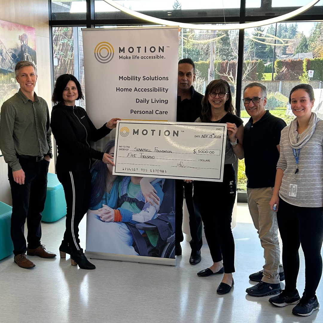 Motion CEO Sue Gilpin and Motion Regional Director Sanjay Prasad presenting large novelty cheque to Sunny Hill Health Centre representatives